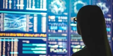 O persoană care se uită la datele de pe un ecran